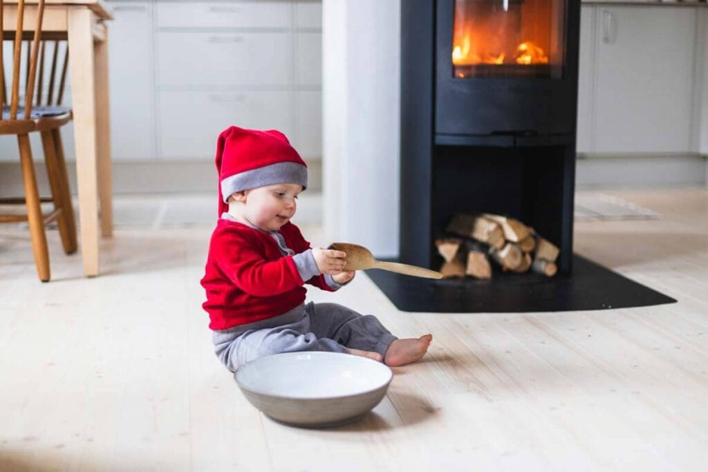 Julkortsfoto taget på en familjefotografering hemma framför öppna spisen.