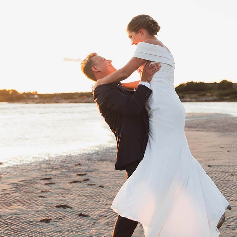 Bröllopsporträtt i solnedången på en strand. Veckra bröllopsbilder i Halland.