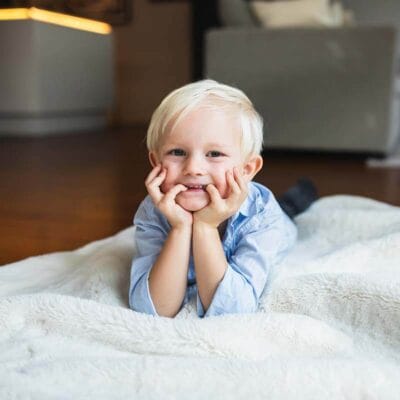 Familjebilder hemma på en mysig filt på golvet. Fotografering hemma med familjen.