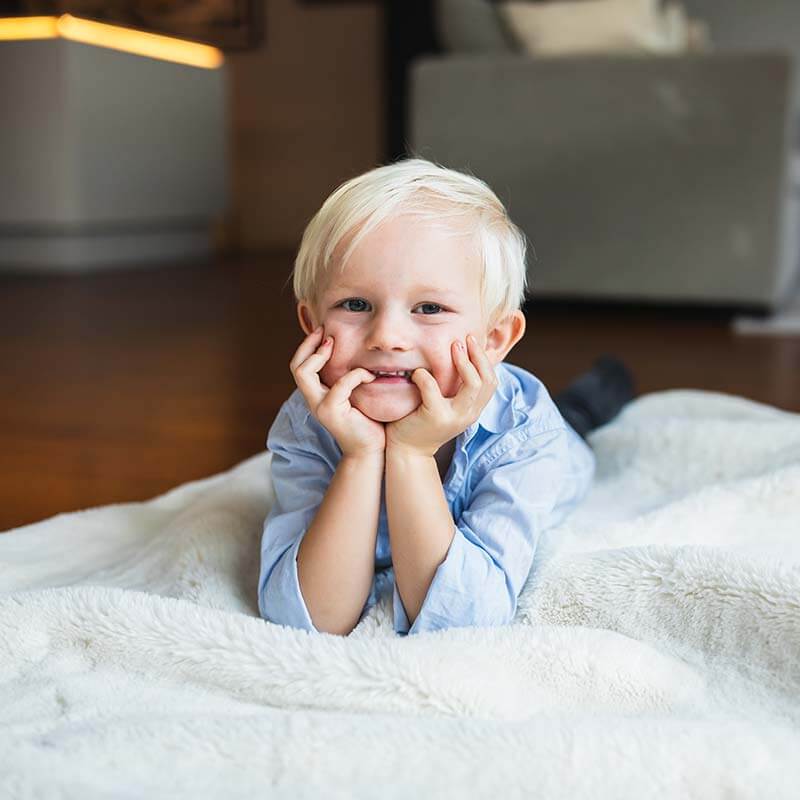 Familjebilder hemma på en mysig filt på golvet. Fotografering hemma med familjen.