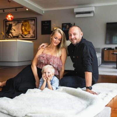 Familjefotografering hemma i vardagsrummet. Familjebilder på en mysig filt.