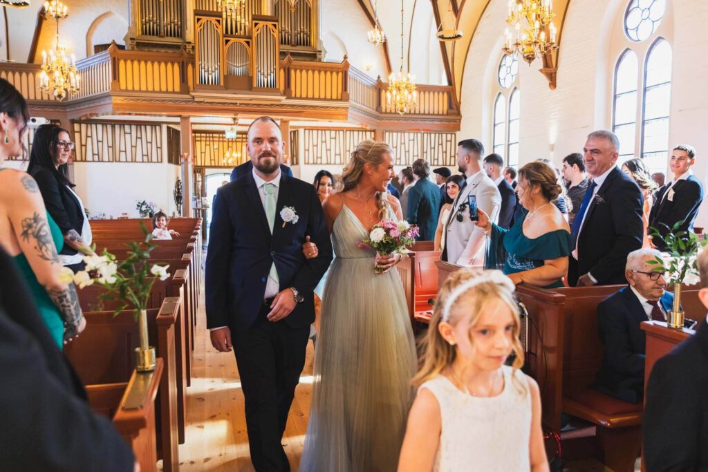 Brudnäbbar och best man som går in i kyrkan tillsammans.